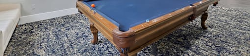 A pool table in a room with a ceiling fan.
