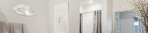 A bathroom with a toilet, sink, and a mirror.