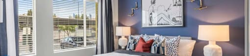 A bedroom with a large bed and a blue lamp.