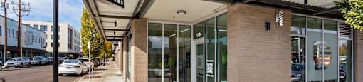 A building with a glass door entrance and a black sign above it.