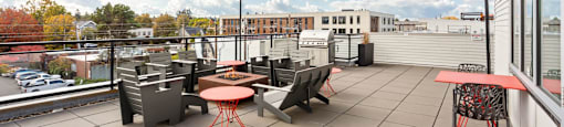 A patio with a table and chairs overlooking a parking lot.
