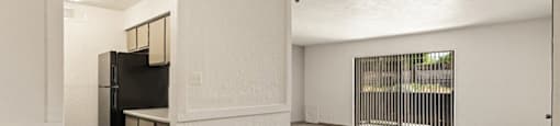 an empty living room with a ceiling fan