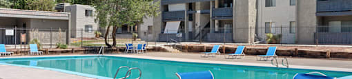 our apartments offer a swimming pool with chairs and a table