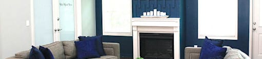 a living room with blue walls and a fireplace with a tv above it
