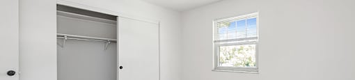 apartment bedroom with a closet and a window