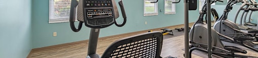 a gym with various machines and a light on the ceiling