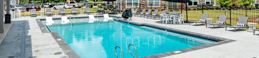 our apartments have a resort style pool with chairs and umbrellas