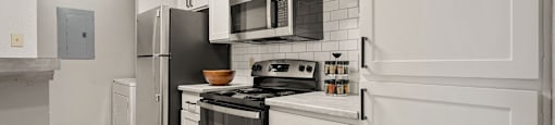 a renovated kitchen with white cabinets and stainless steel appliances