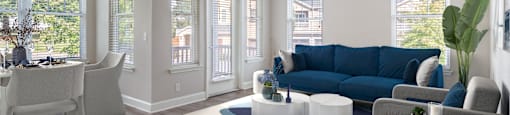 A living room with a blue couch and white chairs.