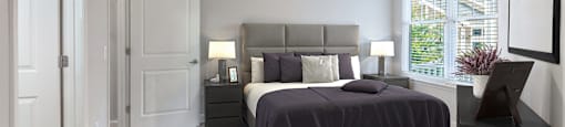 A bedroom with a bed, nightstands, and a ceiling fan.