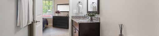 A bathroom with a toilet, sink, and mirror.