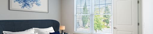 A bedroom with a large window.