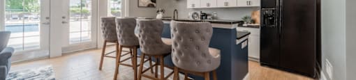 Clubhouse kitchen with a black refrigerator and a dining table with chairs.