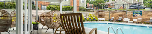 a pool and deck with rocking chairs and a pool