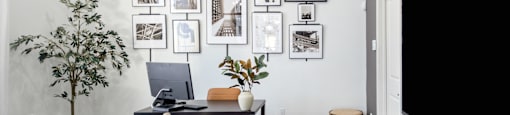 a living room with a couch and a tv and a wall of framed pictures