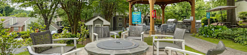 a patio with chairs and tables and a fire pit