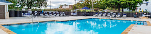 A large swimming pool with a blue water surface and a wooden edge.
