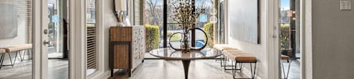 a dining room with a table and chairs in front of a window