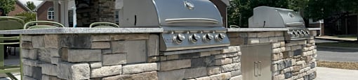 A stone wall with a metal grill on top.