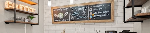 a kitchen with black cabinets and a counter top with a sink and a coffee bar