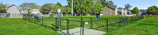 A park with a fence and a sign on a pole.