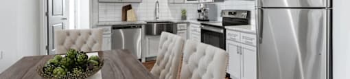 A modern kitchen with a wooden table and white chairs.