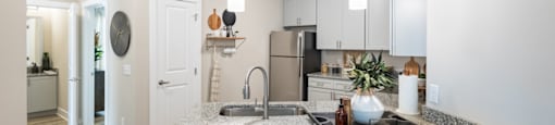 a kitchen with white cabinetry and a granite counter top