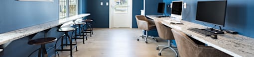 a room with blue walls and a long counter with computers on it
