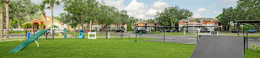 a playground with a slide and trampoline at the whispering winds apartments in pearland,