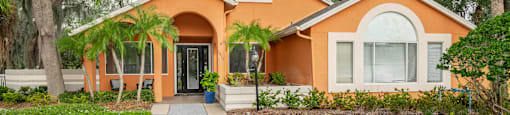 a home with an orange exterior and a walkway leading to the front door