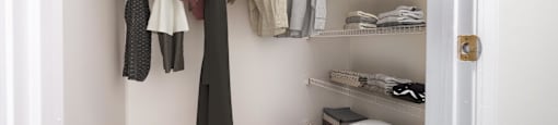 A small walk in closet with shelves and baskets at Amelia Village apartments in Clayton, NC.