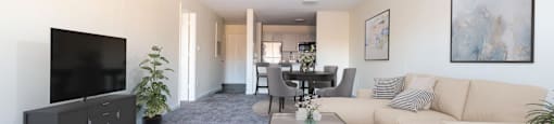 A living room with a couch and a table and a tv at Amelia Village apartments in Clayton, NC.