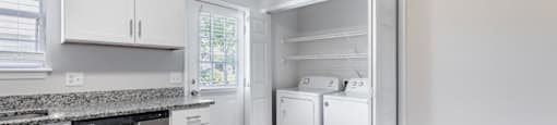 A kitchen with white cabinets and appliances.