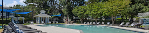 a swimming pool with lounge chairs next to a resort style pool
