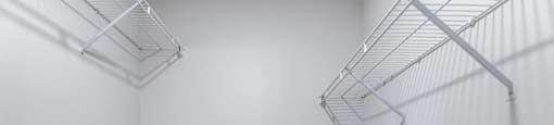 Empty silver shelves in a white room.