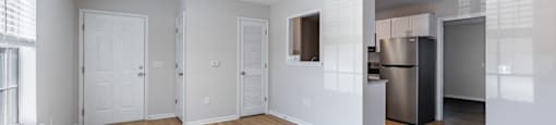 A room with a ceiling fan and wooden flooring.
