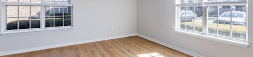 A room with a ceiling fan and wooden flooring.