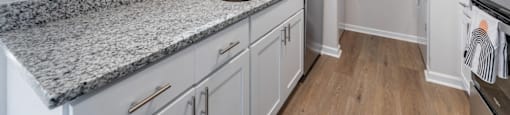 A kitchen with granite countertops and white cabinets.