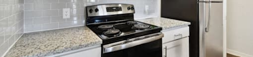 a kitchen with white cabinets and black appliances