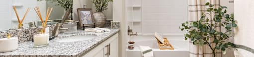 Bathroom with a White Tub, Sink and Hanging Mirror.