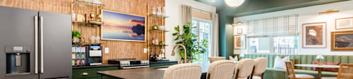 Interior Clubhouse Kitchen with a Refrigerator, Chairs and a Table.