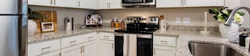 Kitchen with White Cabinets and a Black Stove Top Oven.