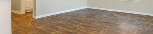 an empty room with hardwood floors and a large window