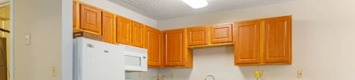 a kitchen with white appliances and wooden cabinets