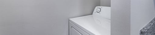 A white washing machine in a small laundry room.
