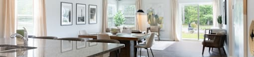 the view of a living room and dining room from the kitchen of a house