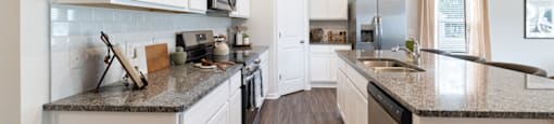 an open kitchen with white cabinets and granite counter tops