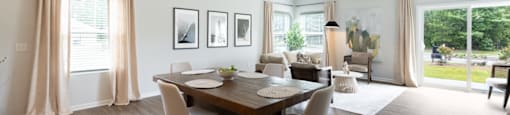 a dining room and living room with a wooden table and chairs