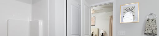 a bathroom with a shower and a sink and a door to a bedroom