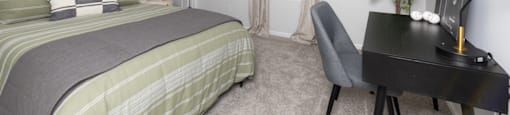 a bedroom with a bed and a desk and a window